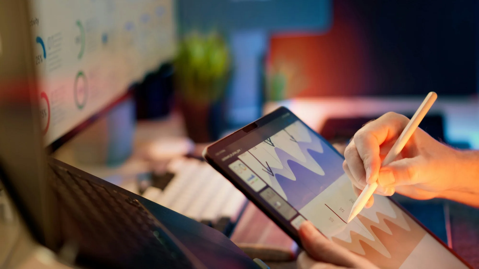 Hand marking up a financial chart on a tablet with a stylus